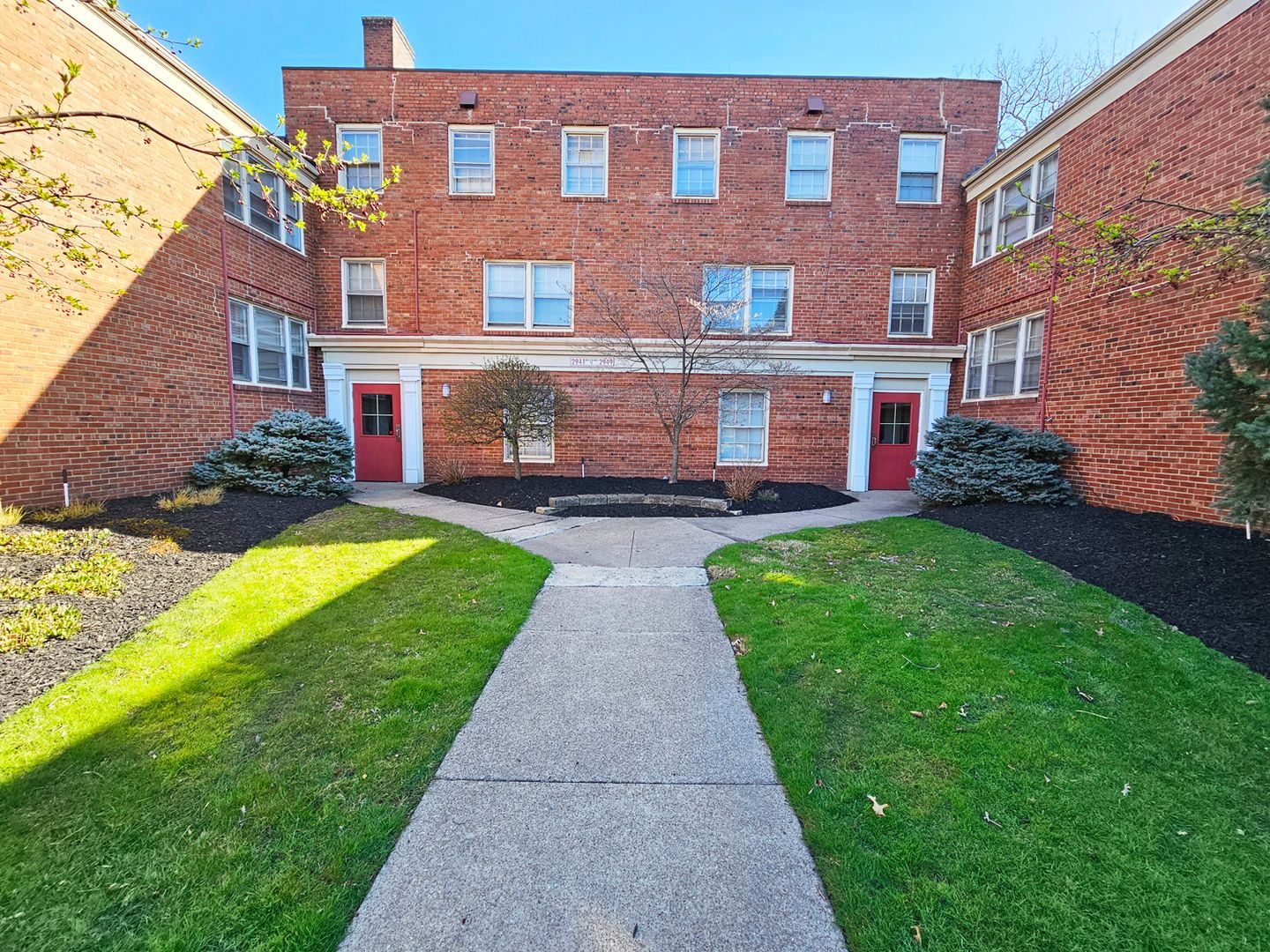 Brick courtyard apartment buildings with new landscaping at Colony Apartments in Shaker Heights.